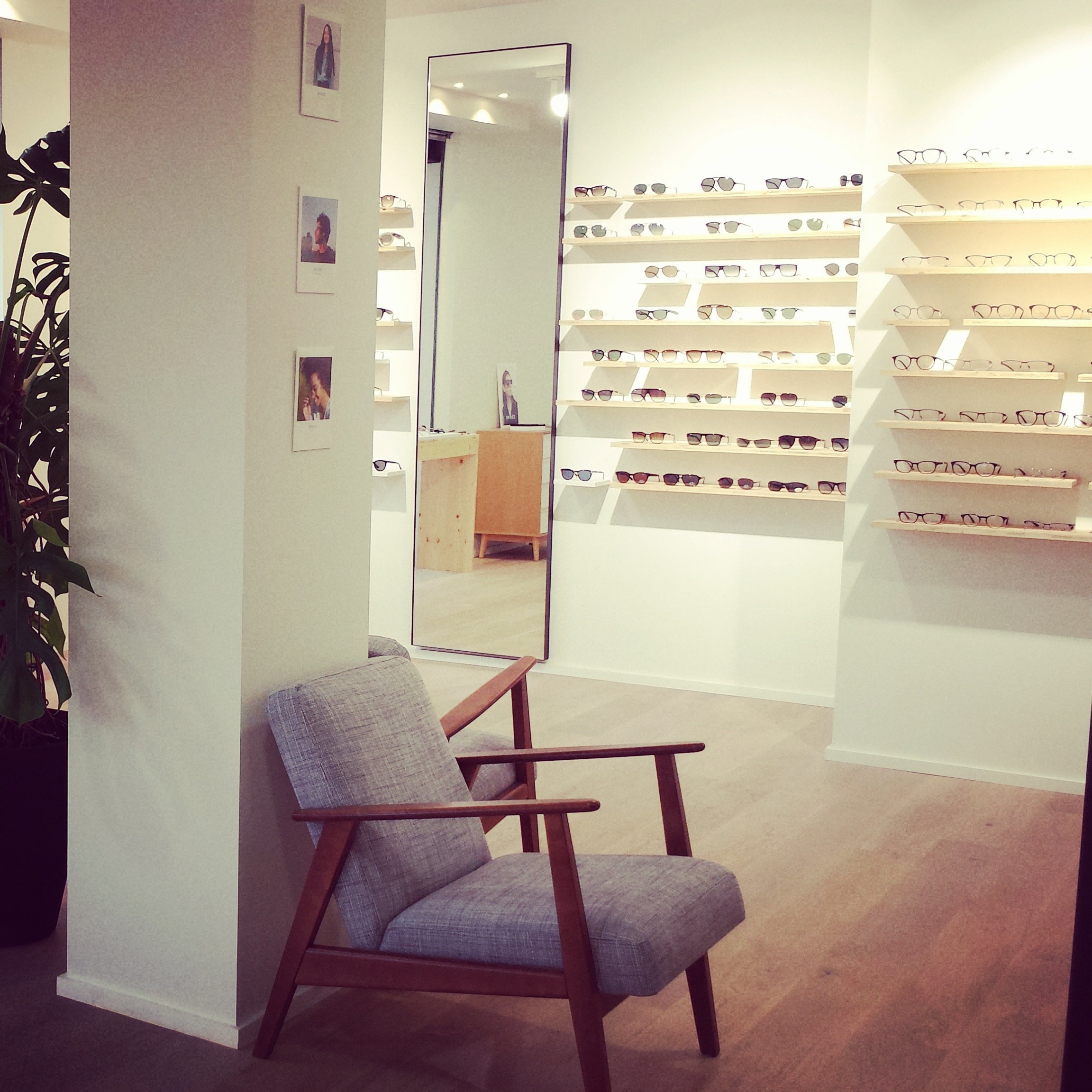 Photo des présentoirs de lunettes solaires et optiques du mur de gauche dans la boutique Louis Richermo Lunetier aux Sept Deniers